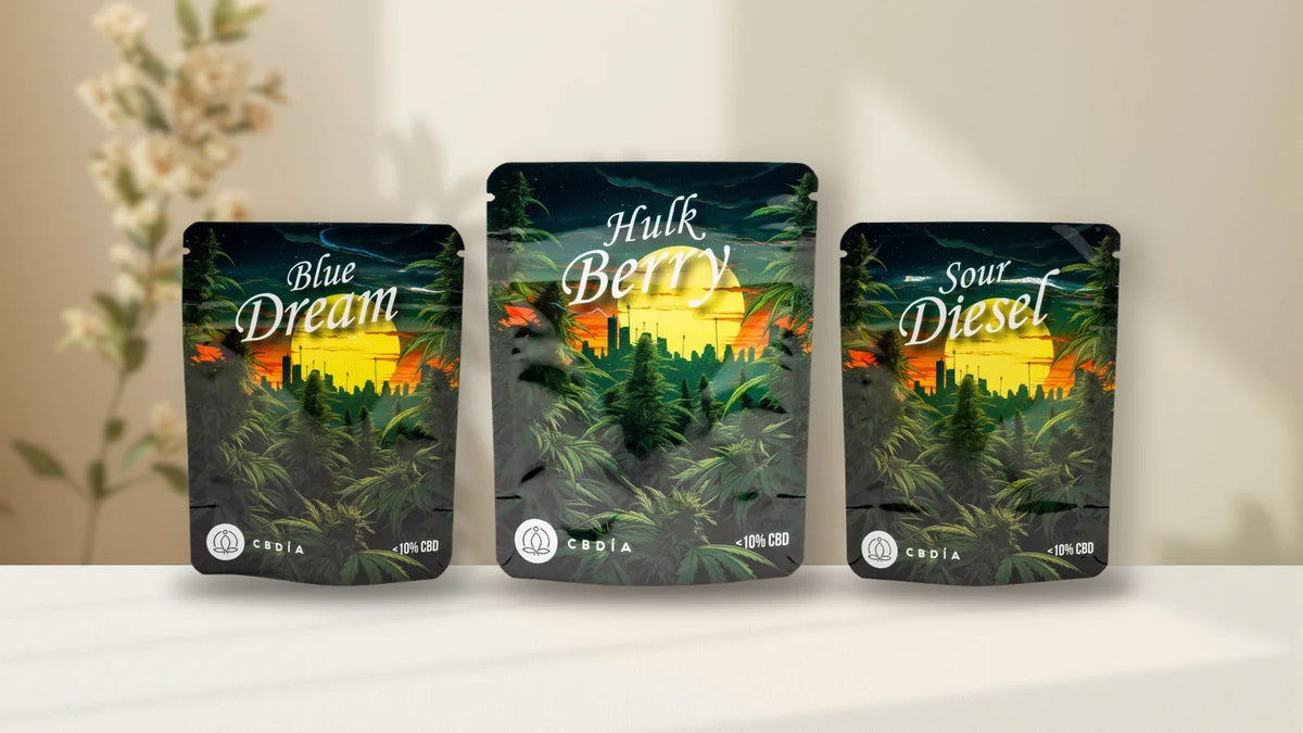 Drei CBDÍA Blütenbeutel Blue Dream, Hulk Berry und Sour Diesel auf hellem Leinen, Titelbild zu CBDÍA Erfahrungen